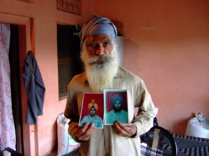 A man shows photos of his sons who were disappeared during the Indian government's counterinsurgency campaign in Punjab.